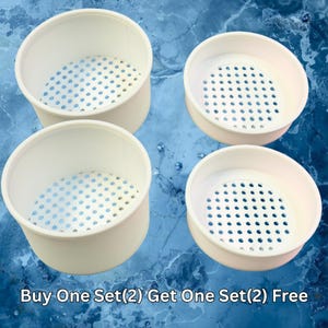 May include: Four white, cylindrical containers with perforated bottoms are displayed against a blue background. The containers have a simple, clean design. Text at the bottom reads "Buy One Set(2) Get One Set(2) Free."