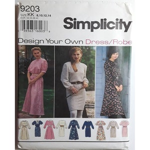 May include: Simplicity sewing pattern for a dress or robe. The pattern features multiple dress designs, including a pink dress with short sleeves and a floral print dress. The pattern size is KK 8, 10, 12, 14.