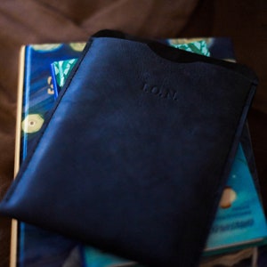 May include: A dark blue leather wallet with the word "L.O.M." embossed on the front.
