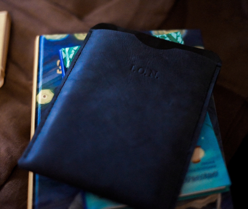 May include: A dark blue leather wallet with the word "L.O.M." embossed on the front.