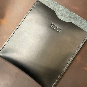 May include: Black leather wallet with a single pocket and the word "HIDG" embossed on the front.