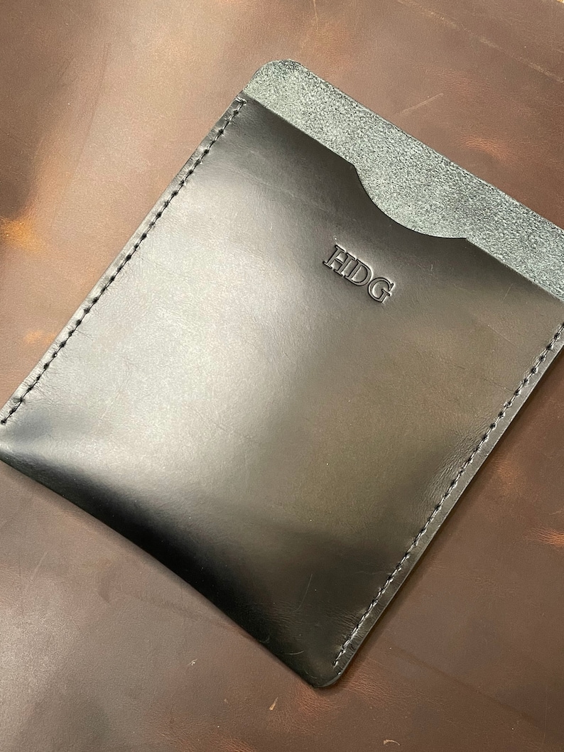 May include: Black leather wallet with a single pocket and the word "HIDG" embossed on the front.