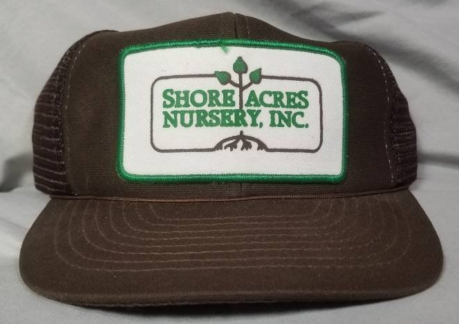 May include: Brown trucker hat with a green and white patch that reads "Shore Acres Nursery, Inc." and a green plant illustration.