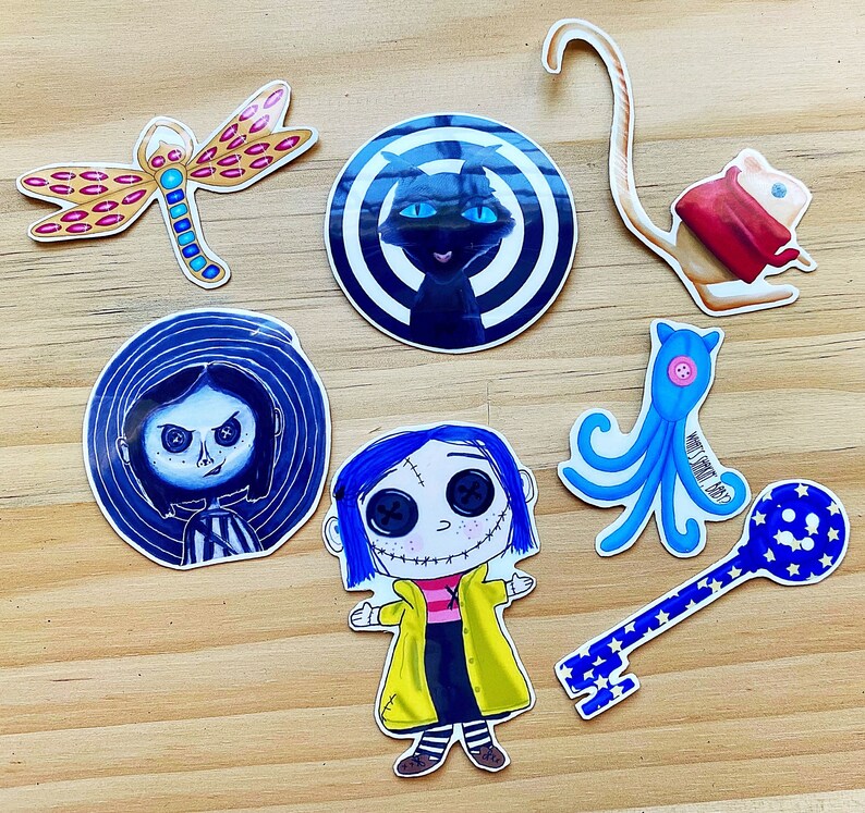 Puede incluir: Un conjunto de diez pegatinas coloridas con varios personajes y dise&ntilde;os. Las pegatinas incluyen un gato negro con un dise&ntilde;o de espiral blanco, un pulpo azul, una llave con una estrella azul, una ni&ntilde;a con cabello azul, una ni&ntilde;a con cabello negro, una lib&eacute;lula y un rat&oacute;n blanco con ropa roja.