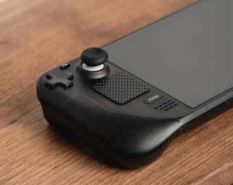 May include: A black handheld gaming device with a touchscreen display, a circular control pad, and a button labeled "STEAM".