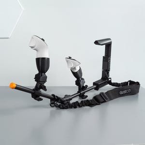May include: A black and white gaming controller mount with a black strap that says "GLISTCO". The mount has two controllers attached to it, one white and one black.