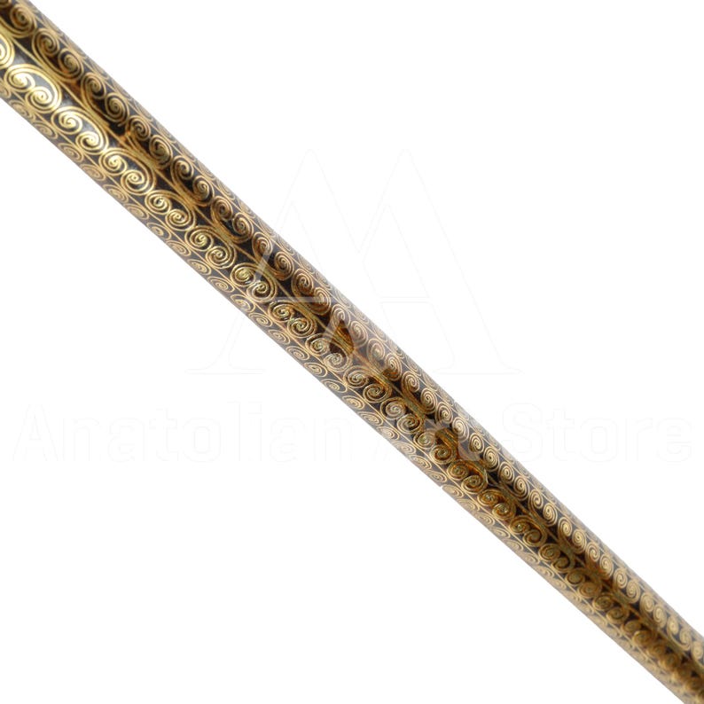 May include: A close-up of a black and gold decorative walking stick with a swirling pattern.
