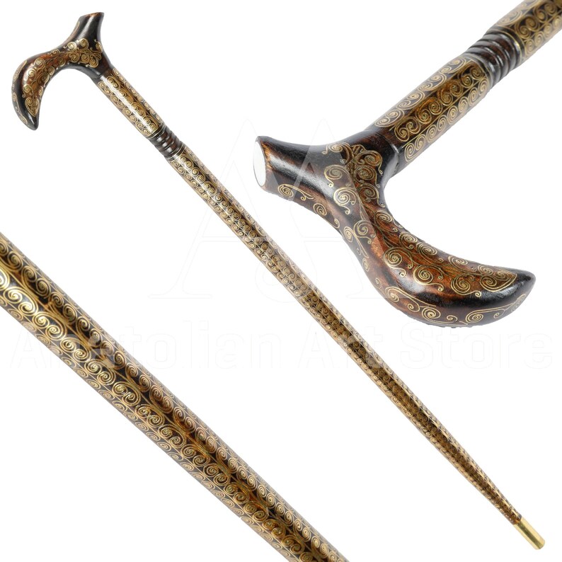May include: A wooden walking stick with a curved handle. The handle and shaft are decorated with intricate gold swirls.