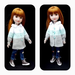 Puede incluir: Una muñeca con un suéter tejido a rayas blancas, azul claro y grises. El suéter tiene un cuello blanco y botones en la parte delantera. La muñeca lleva pantalones vaqueros azules y zapatos plateados.