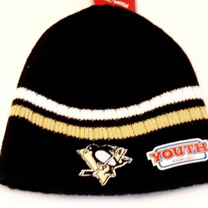 May include: Black knit beanie with a white and gold stripe, a Pittsburgh Penguins logo, and a "YOUTH" label.