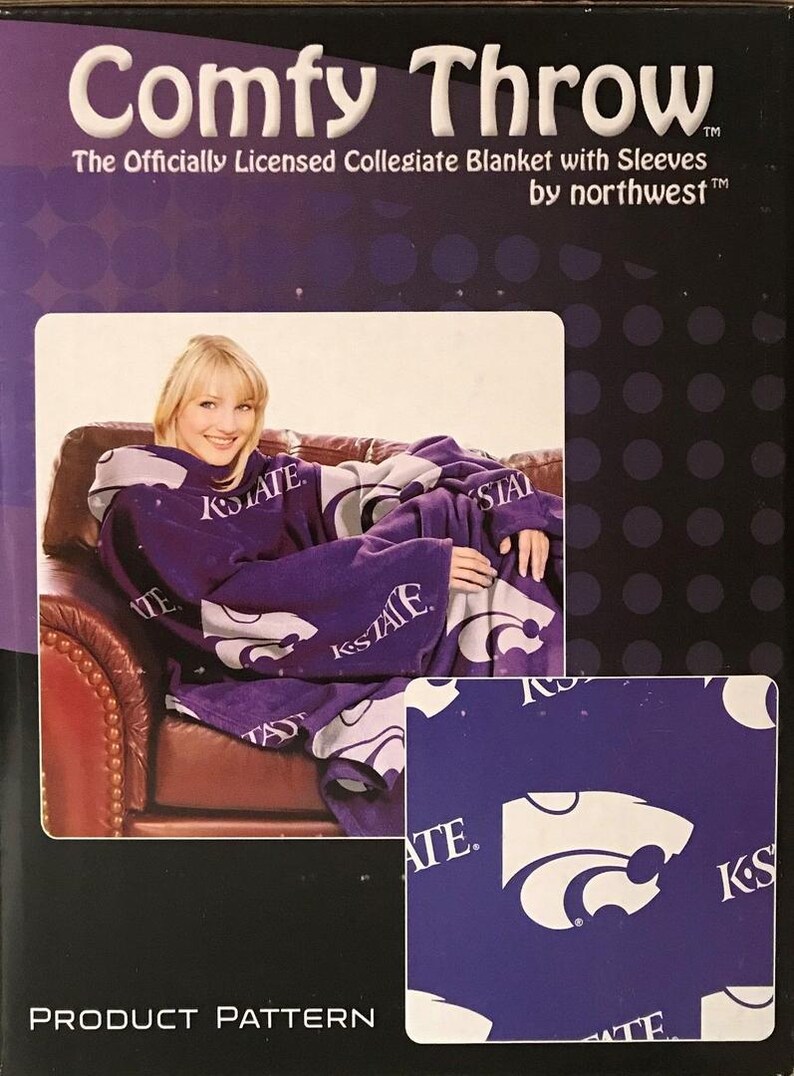 May include: Purple fleece blanket with sleeves featuring the Kansas State Wildcats logo and "K-State" text. The blanket is shown on a person sitting on a couch. The product packaging includes the text "Comfy Throw The Officially Licensed Collegiate Blanket with Sleeves by northwest&trade;&trade;".