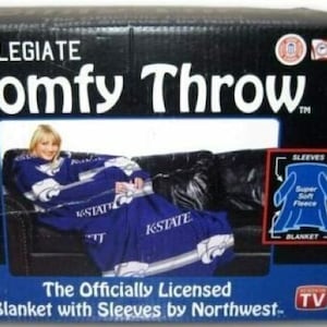 May include: A purple and blue collegiate blanket with sleeves. The blanket features the text "K-State" and a logo. The packaging shows a person wearing the blanket on a couch. The text on the packaging reads "Collegiate Comfy Throw The Officially Licensed Blanket with Sleeves by Northwest... TV"