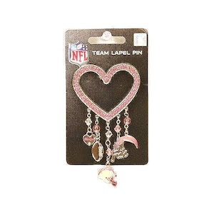 May include: A heart-shaped team lapel pin with pink rhinestones and dangling charms. The pin features the NFL logo and the words "TEAM LAPEL PIN". Charms include a heart, football, and helmet.
