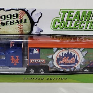 May include: A 1999 limited edition New York Mets Team Collectible semi-truck toy. The truck is blue and orange with the Mets logo and "New York" repeated on the side. The truck is on a green and white background.