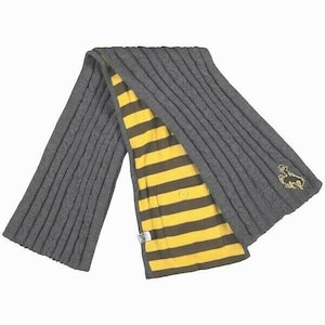 May include: A gray knitted scarf with a yellow and brown striped lining. The scarf has a small embroidered design on one end.