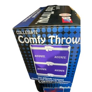 May include: Collegiate Comfy Throw blanket with sleeves, featuring the K-State logo in purple and white on a blue background. The officially licensed blanket is made by Northwest.