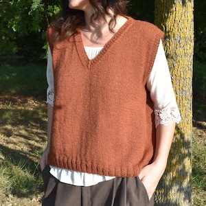 Può includere: Un gilet di maglia senza maniche di colore ruggine con scollo a V.