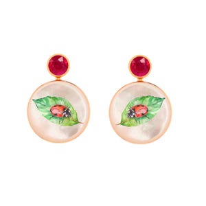May include: A pair of gold-toned earrings. Each earring features a round, mother-of-pearl design with a watercolor painting of a ladybug on a green leaf. A red gemstone tops each earring.