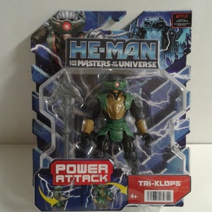 以下が含まれることがあります： He-Man and the Masters of the Universe Power AttackシリーズのTri-Klopsの緑と金のフィギュア。フィギュアは銀色の武器を持っており、Netflixのロゴが入った青と赤の箱にパッケージされています。