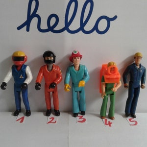 May include: Five plastic action figures of different professions, including a race car driver, a pilot, a firefighter, a scuba diver, and a construction worker. The figures are all wearing different colored uniforms and helmets.