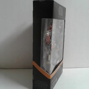May include: A black and orange Star Wars The Black Series action figure box featuring a character named "Cobb Vanth".
