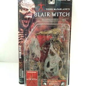 Puede incluir: Una figura de acción de McFarlane Toys de la franquicia Blair Witch, empaquetada en una funda de plástico transparente. La figura es un monstruo con una prenda blanca rasgada. El embalaje presenta el título de la película y un gráfico de la cara de un monstruo.