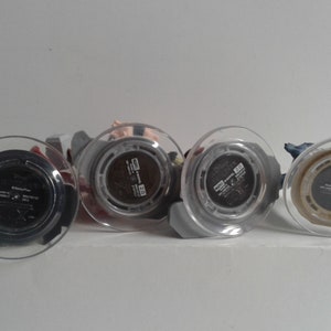 May include: Four small plastic figurines with clear plastic bases. The bases have black labels with white text. The text on the labels reads "Disney", "Marvel", "Star Wars", and "Pixar".