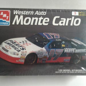 Pu&ograve; includere: Scatola di un modellino di un'auto da corsa Western Auto Monte Carlo. La scatola presenta un'immagine dell'auto con il numero 17 e le parole "PARTS AMERICA" sono visibili sull'auto. La scatola ha anche il logo AMT.