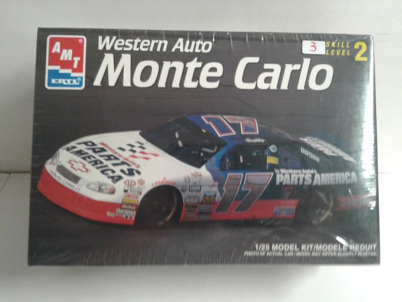 Pu&ograve; includere: Scatola di un modellino di un'auto da corsa Western Auto Monte Carlo. La scatola presenta un'immagine dell'auto con il numero 17 e le parole "PARTS AMERICA" sono visibili sull'auto. La scatola ha anche il logo AMT.