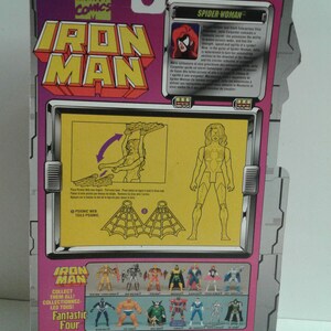 May include: Back of a pink and white cardboard package for a Spider-Woman action figure. The package features a photo of the figure and a description of the character. The text reads "Spider-Woman". The package also includes a photo of the figure's web and instructions on how to use it. The package also includes a photo of other action figures from the same series, including Iron Man, Fantastic Four, and others.