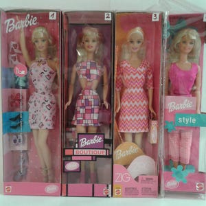 Może przedstawiać: Cztery lalki Barbie w oryginalnym opakowaniu. Każda lalka jest blondynką i ma na sobie inny strój. Opakowanie jest różowe i zawiera logo Barbie. Na jednym pudełku widnieje napis "Barbie Boutique", a na innym "Barbie Style".