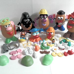 May include: A collection of Mr. Potato Head toys and accessories. The toys are various colors and feature different outfits and accessories, including hats, glasses, and tools. The accessories are scattered around the potato-shaped figures.