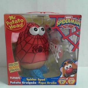 May include: A boxed Mr. Potato Head toy, styled as Spider-Man. The red potato figure has a spiderweb pattern and large white eyes. The packaging includes the Marvel Spider-Man logo and the words "Spider Spud".