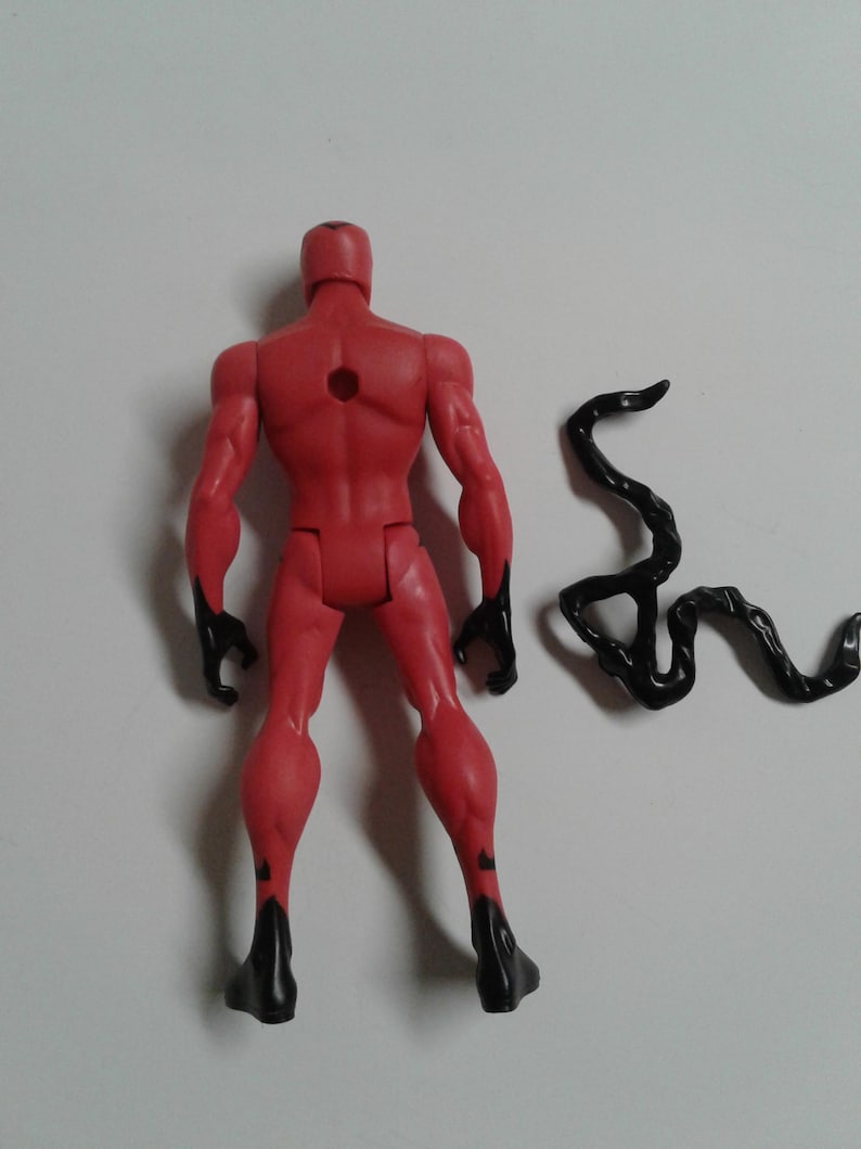 Pode incluir: Figura de a&ccedil;&atilde;o vermelha com detalhes pretos, em p&eacute; com um acess&oacute;rio de cauda preto. A figura tem um furo nas costas.