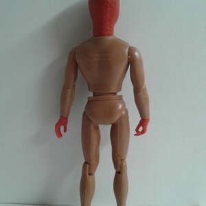 Op de afbeelding: Een rood en bruin plastic actieve figuur met een rood masker. De figuur heeft scharnierende armen en benen.