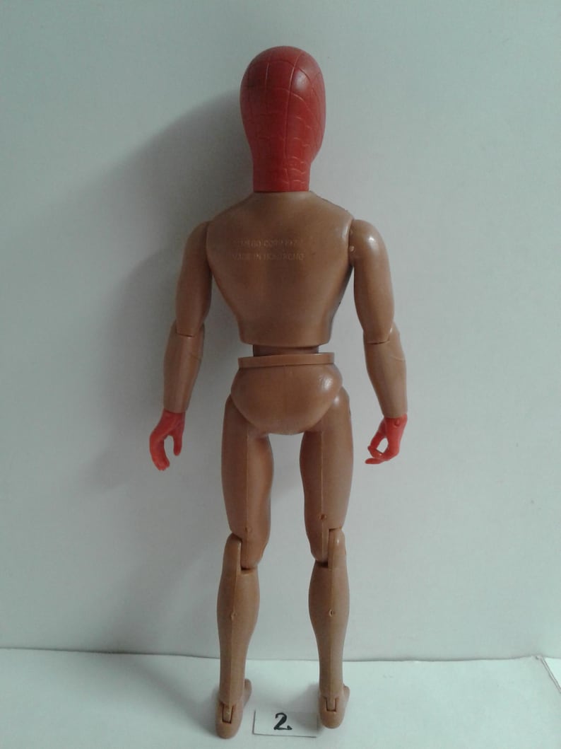 Op de afbeelding: Een rood en bruin plastic actieve figuur met een rood masker. De figuur heeft scharnierende armen en benen.