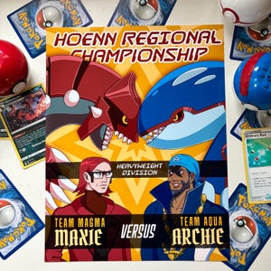 May include: A rectangular poster titled Hoenn Regional Championship featuring Groudon and Kyogre above Team Magma leader Maxie and Team Aqua leader Archie. The text reads Heavyweight Division, Team Magma Maxie, Versus, and Team Aqua Archie.