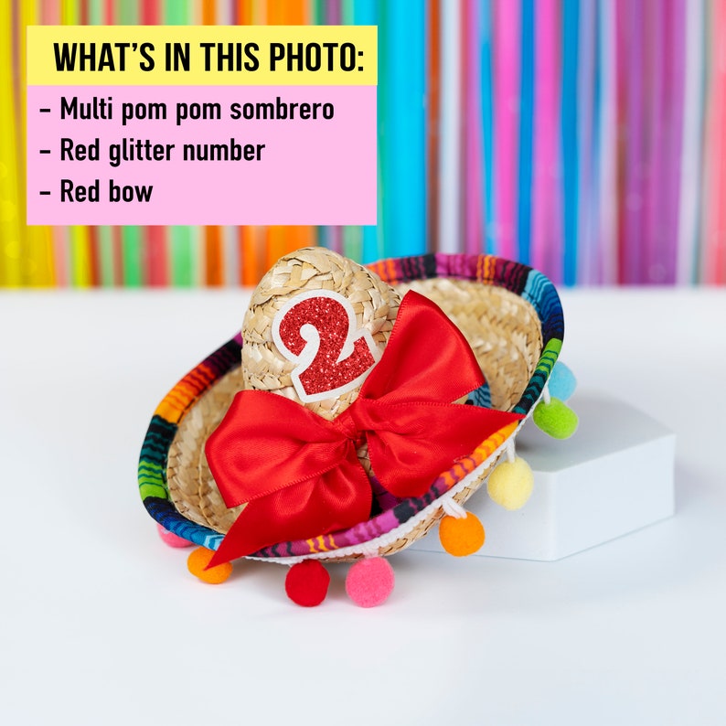 May include: A small, multi-colored pom pom sombrero with a red glitter number "2" and a red bow.
