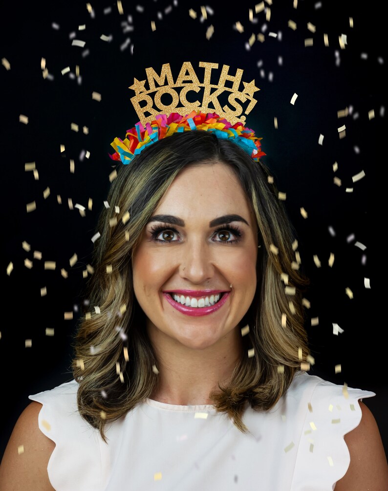 K&ouml;nnte beinhalten: Eine Frau tr&auml;gt ein goldenes Glitzer-Haarband mit dem Text "MATH ROCKS!" darauf. Sie l&auml;chelt und Konfetti f&auml;llt um sie herum.