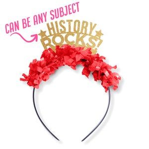 May include: Gold glitter headband with the words "HISTORY ROCKS!" and red tissue paper streamers. The headband can be used for any subject.