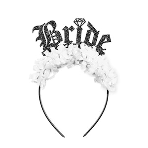 May include: Black headband with a white tulle bow and a black glitter "Bride" sign with a diamond on top.