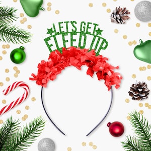 Puede incluir: Una diadema festiva con el texto "LET'S GET ELF'ED UP" en purpurina verde. La diadema presenta una franja roja y est&aacute; rodeada de adornos navide&ntilde;os, agujas de pino y un bast&oacute;n de caramelo sobre un fondo blanco.