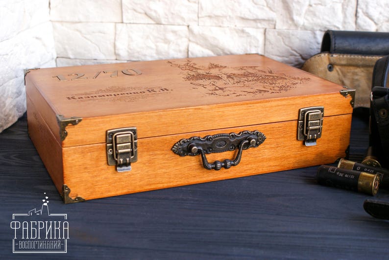 May include: A wooden box with a hinged lid and a metal handle. The box is engraved with the text "12/70 Kalinina K.H.".