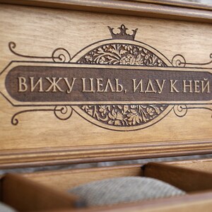 May include: A wooden box with a decorative inscription that reads "Вижу цель, иду к ней" (I see the goal, I go to it). The box has a crown design and floral patterns.