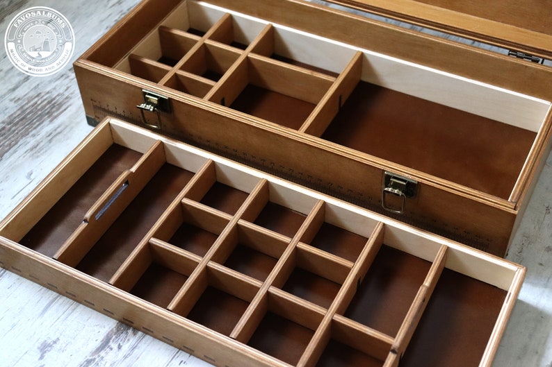 May include: A wooden box with two drawers, each with multiple compartments. The top drawer has a brown felt lining and the bottom drawer has a brown felt lining. The box has a brass latch and hinges.