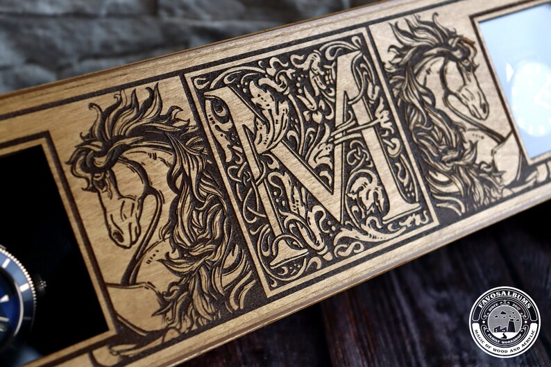 May include: A wooden watch box with a black velvet interior and three compartments. The box is decorated with a laser-engraved design featuring a horse, a letter "M" with floral accents, and another horse. The box has a circular logo on the bottom right corner that reads "Favosalums Made of Wood and Acrylic".
