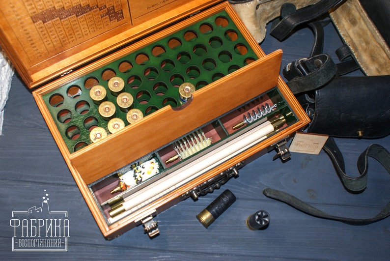 May include: A wooden box with a green felt lining and a compartment for shotgun shells. The box also has a drawer with cleaning supplies and a cleaning rod. The box is open and the drawer is pulled out. The box is labeled "Фабрика -воспроизведения-."