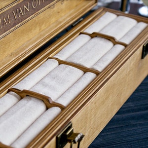 May include: A wooden box with a hinged lid and a velvet interior. The box has a personalized inscription that reads "Maxim Van Off".