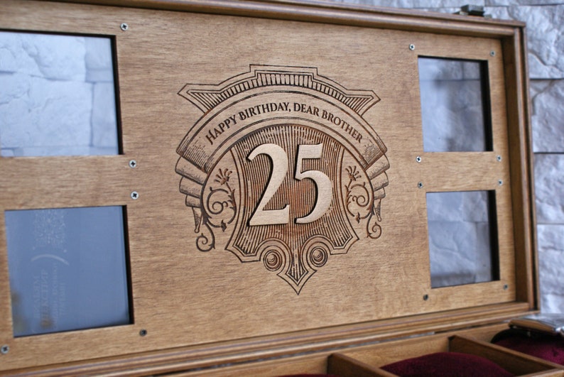 May include: A wooden box with a decorative engraved design that says "Happy Birthday, Dear Brother 25". The box has two glass windows on the top and a red velvet interior.