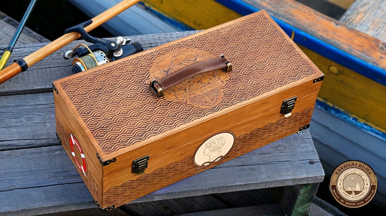 May include: A rectangular wooden storage box with a brown leather handle and brass-colored metal latches. The lid features a laser-engraved wave pattern and the text "ALWAYS COMING BACK HOME TO YOU". A circular inlay shows a profile silhouette.